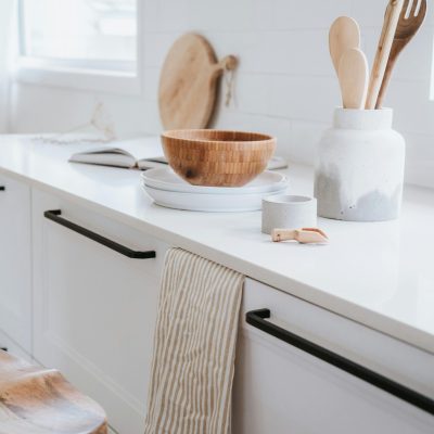 A beautifully minimalist Japandi style kitchen with wooden utensils, ceramics, and a bright, airy feel.